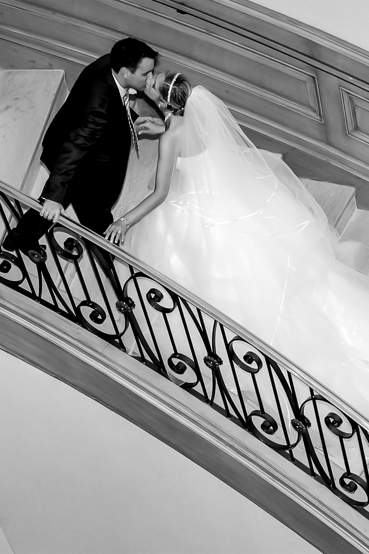 Bride and groom kissing on an architectural balcony in Las Vegas during a destination wedding