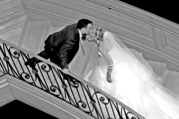 Bride and groom on staircase with flowing veil wedding portrait