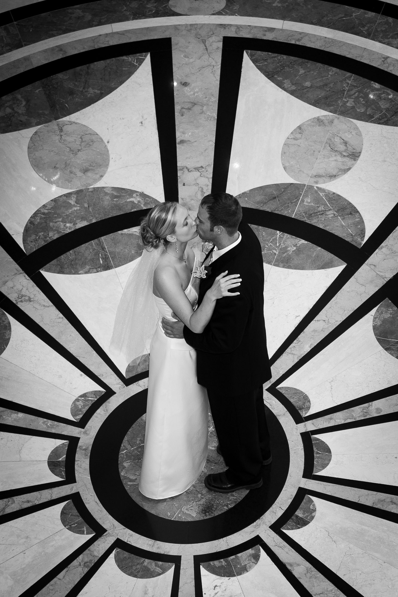 Couple sharing a kiss on the patterned marble floor at Bellagio Las Vegas wedding