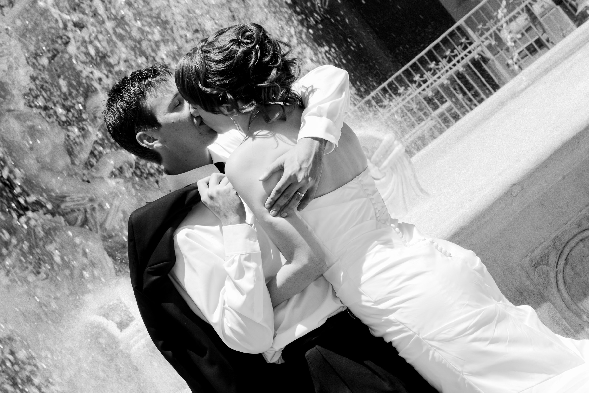 Bride and groom sharing a romantic moment in front of grand estate architecture in black and white