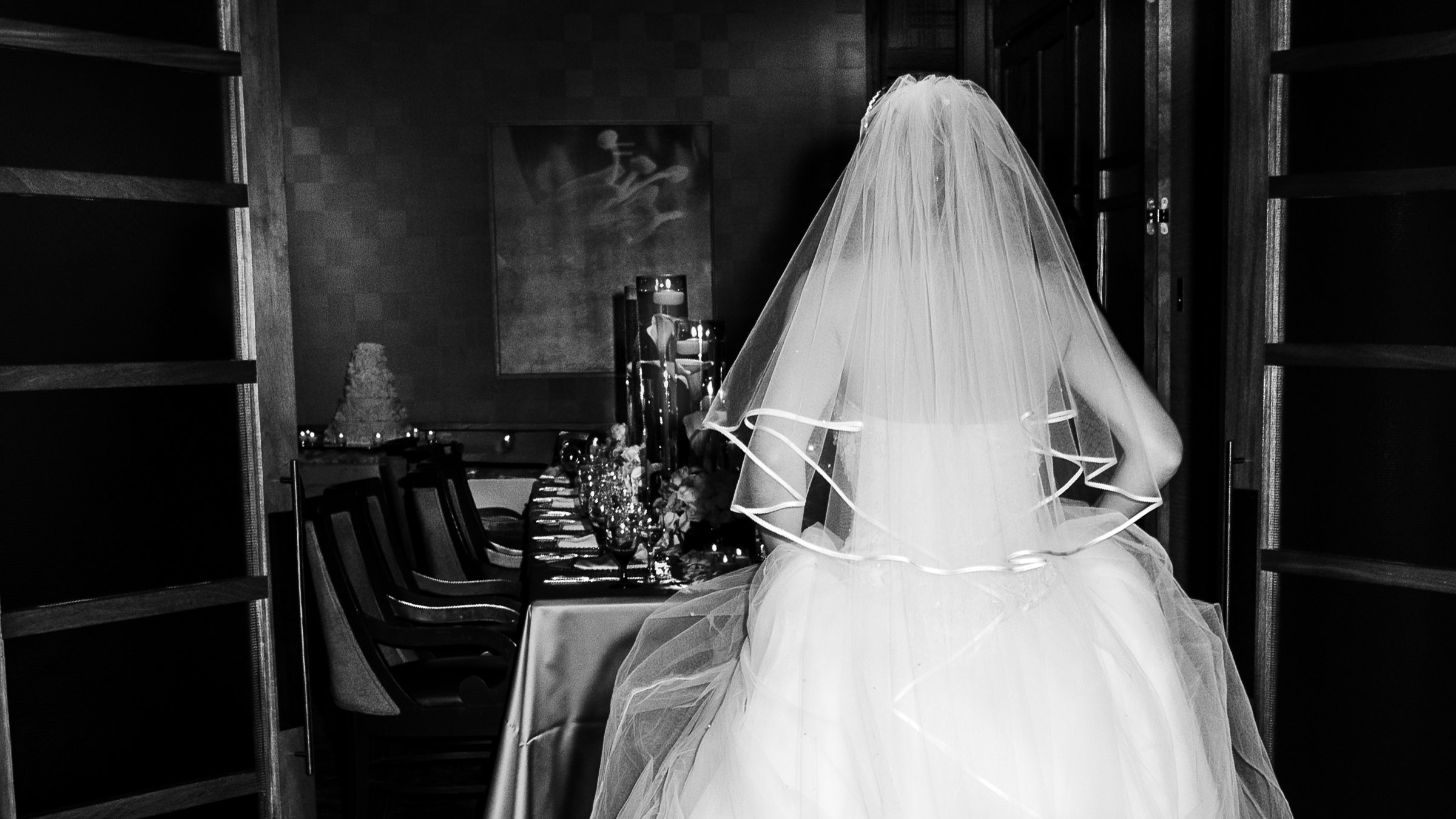 Bride entering an intimate luxury wedding reception with candlelit table setting captured in editorial style