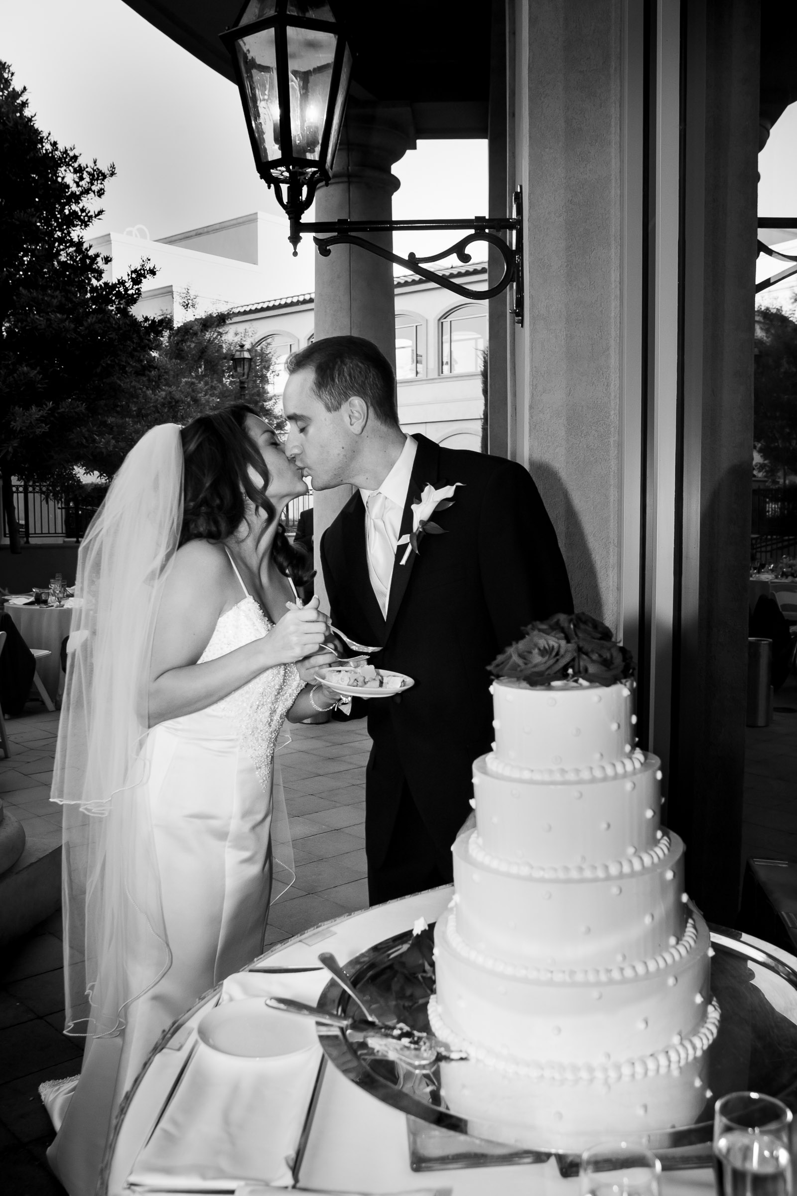 Bride and groom sharing a polite kiss during cake cutting at their private luxury reception Hilton Lake Las Vegas wedding.