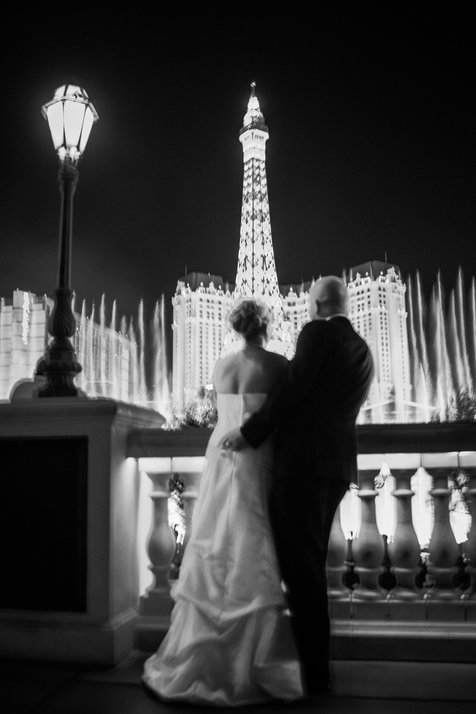 Couple overlooking Bellagio fountains at night in Las Vegas captured in a cinematic editorial wedding photography style