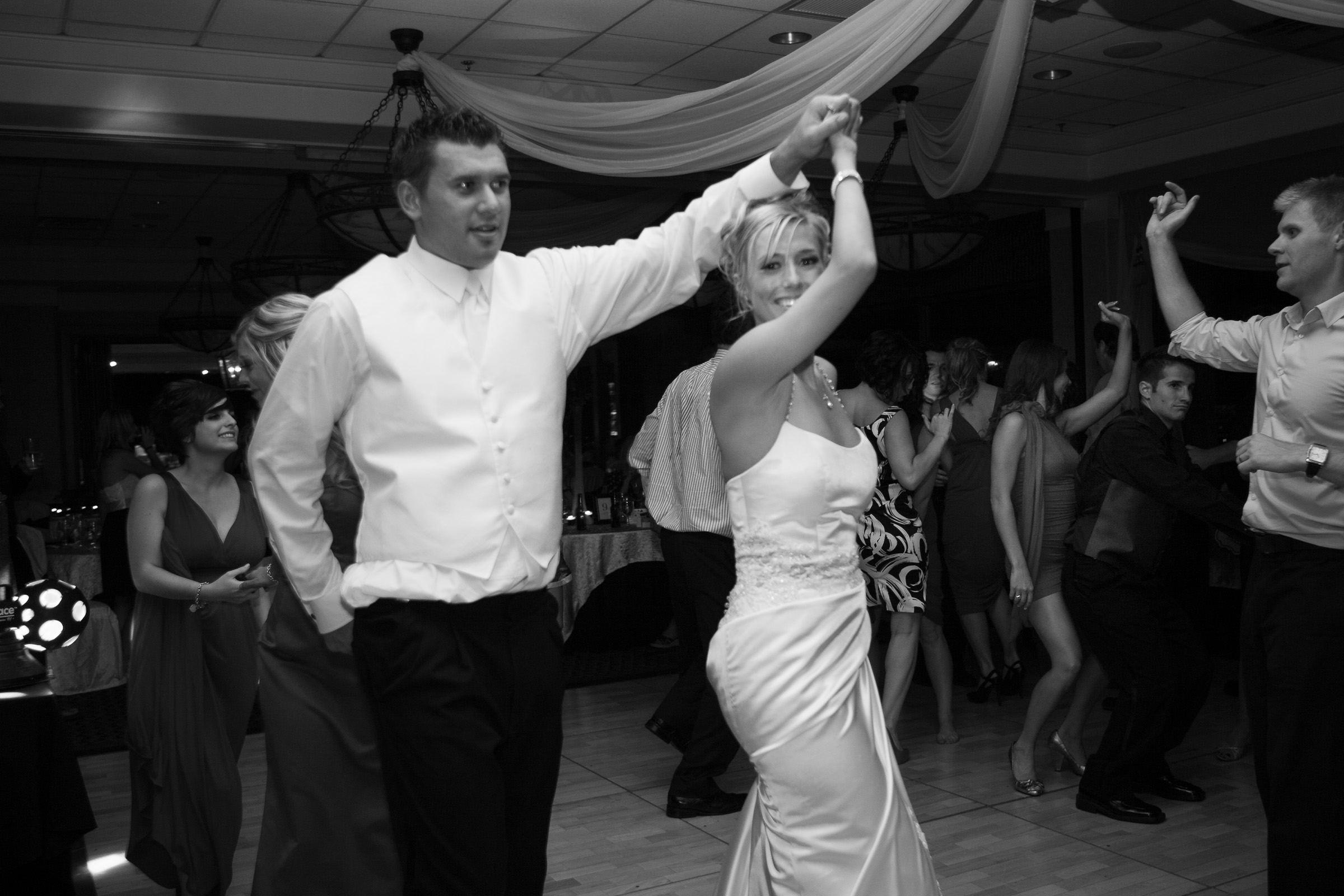 Black and white candid of bride and groom dancing