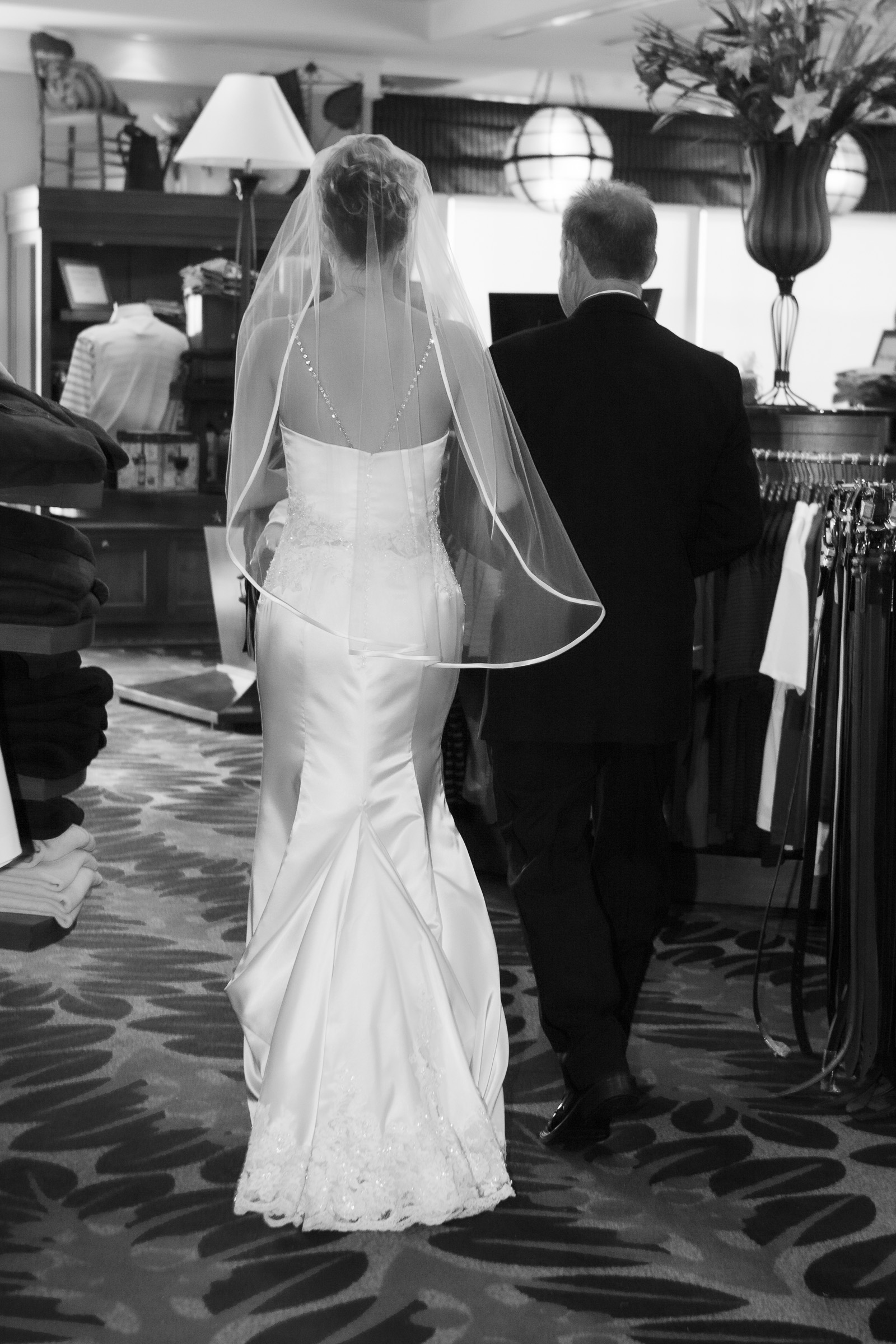 Documenting the bride and the detail on the back of her dress while exiting to ceremony through the golf club shop